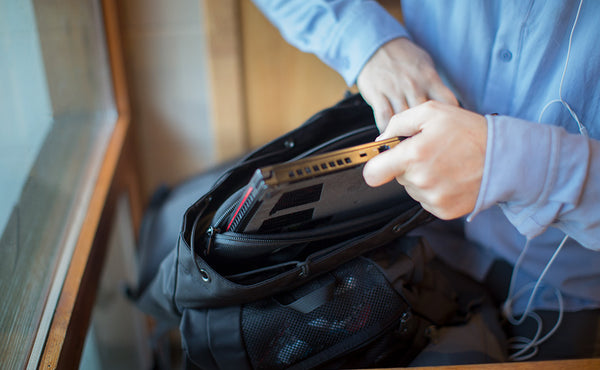 A person removing their laptop from the main compartment of the Original Shadow Guide 31.